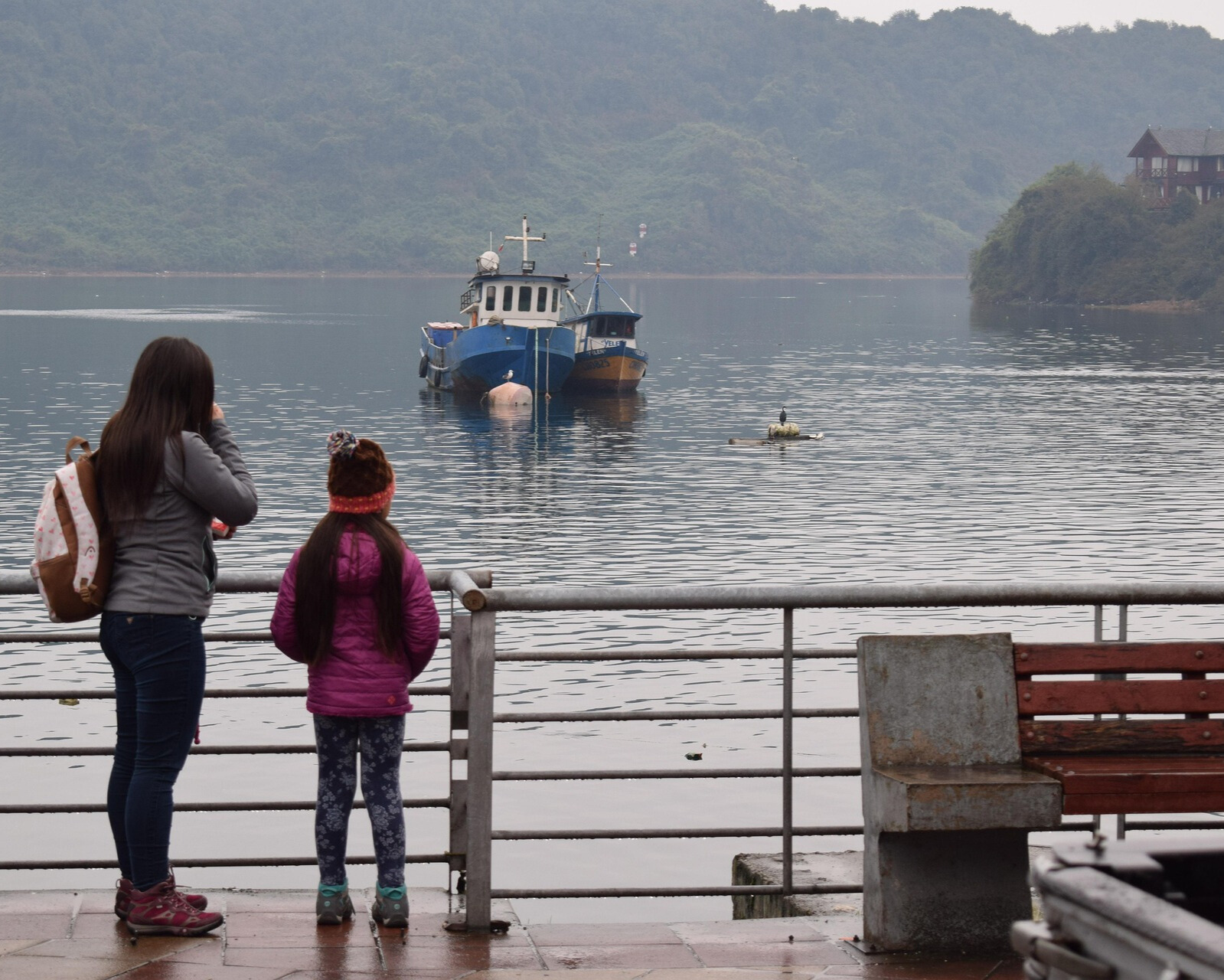 Mujer y niña viendo un barco 